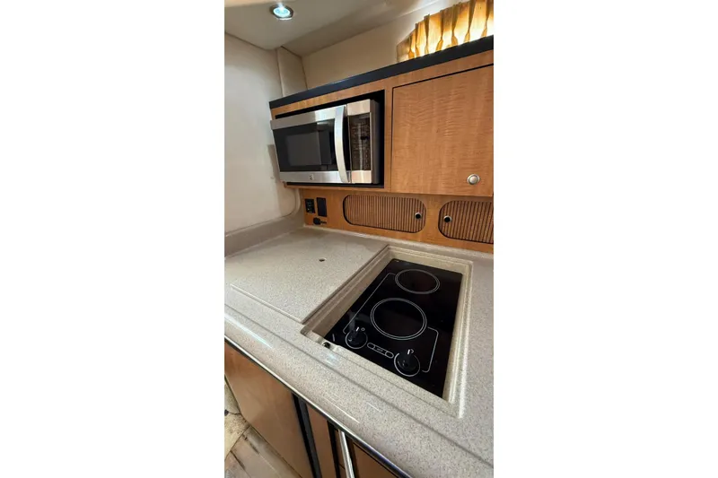 Slide: The Image of 2006 Sea Ray 340 Sundancer kitchen with microwave and stovetop. - 12