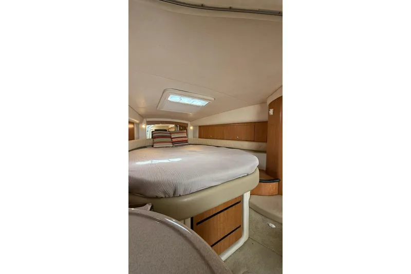 Slide: The Image of 2006 Sea Ray 340 Sundancer cabin interior with bed and striped pillows. - 14