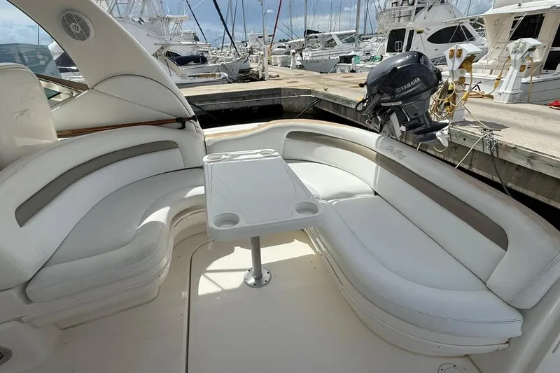 Slide: The Image of 2006 Sea Ray 340 Sundancer boat interior with white seating and table at marina. - 3