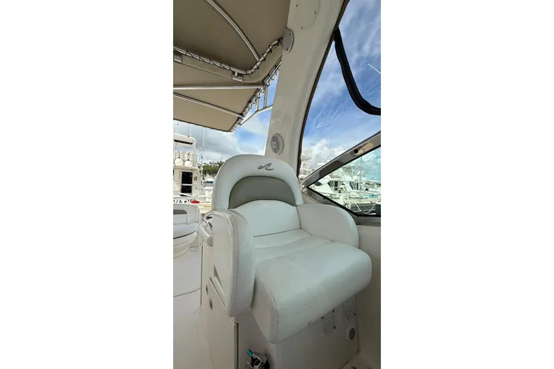 Slide: The Image of Captain's seat on 2006 Sea Ray 340 Sundancer yacht, under canopy, with marina view. - 5