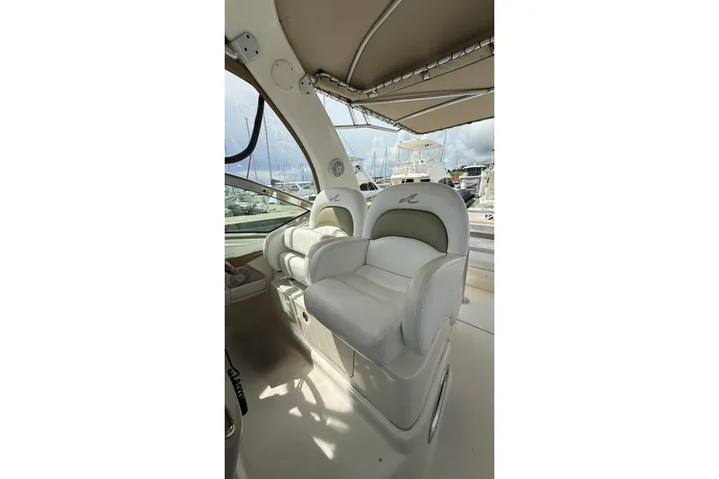 Slide: The Image of 2006 Sea Ray 340 Sundancer cockpit with plush seating and marina view. - 6