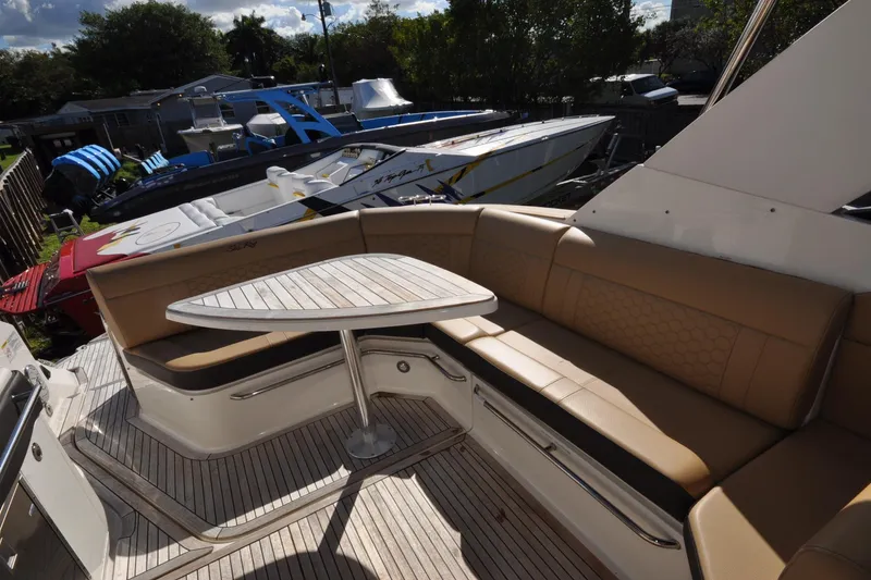 Slide: The Image of 2020 Sea Ray Sundancer 320 yacht with tan seating and wooden deck, docked outdoors. - 10