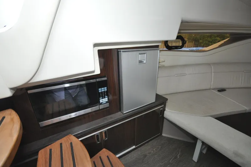 Slide: The Image of Interior of 2020 Sea Ray Sundancer 320 with kitchenette and seating area. - 13