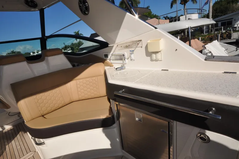 Slide: The Image of 2020 Sea Ray Sundancer 320 interior with beige seating and kitchenette area. - 9