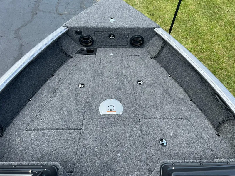 Slide: The Image of 2026 Lund 1875 Impact XS Sport boat interior with carpeted deck and storage compartments. - 10