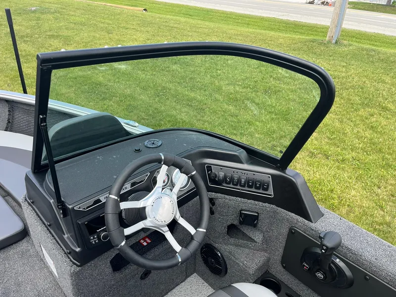 Slide: The Image of 2026 Lund 1875 Impact XS Sport boat dashboard with steering wheel and control panel. - 15