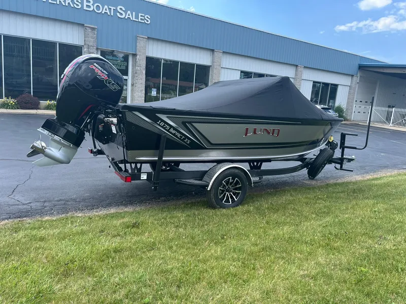 Slide: The Image of 2026 Lund 1875 Impact XS Sport boat on trailer outside dealership. - 4