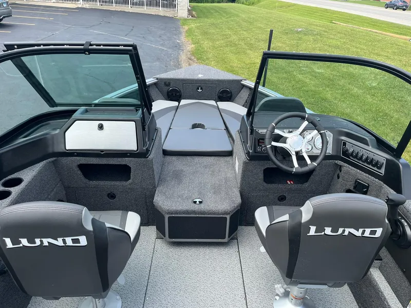 Slide: The Image of 2026 Lund 1875 Impact XS Sport boat interior with steering wheel and seating. - 8