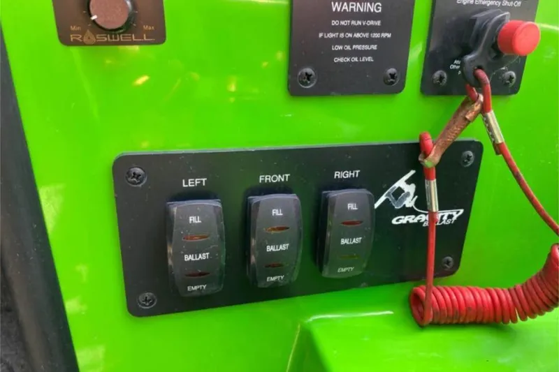 Slide: The Image of 2011 Moomba Mobius LSV ballast control panel with switches and warning labels. - 8