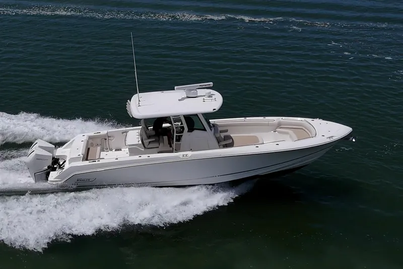 Slide: The Image of 2020 Boston Whaler 330 Outrage cruising on open water, showcasing sleek design and powerful performance. - 11