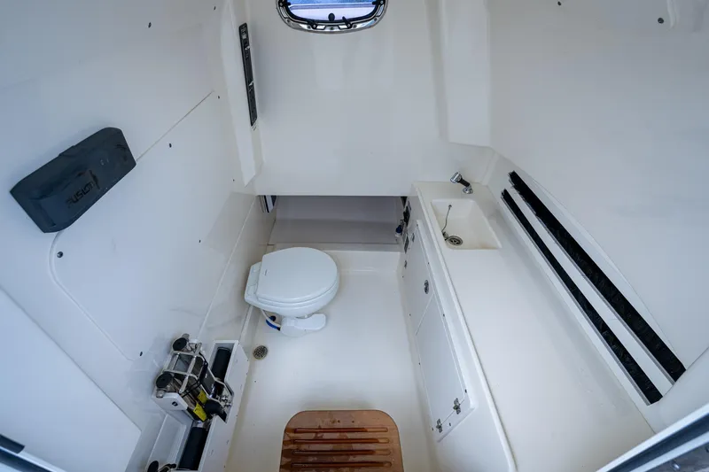 Slide: The Image of 2020 Boston Whaler 330 Outrage boat interior with toilet and sink. - 14