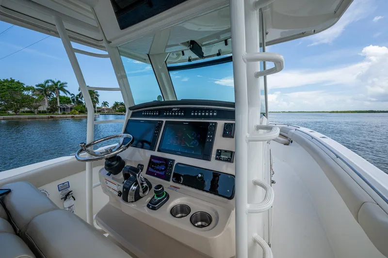 Slide: The Image of 2020 Boston Whaler 330 Outrage helm with advanced navigation system on a calm waterway. - 20
