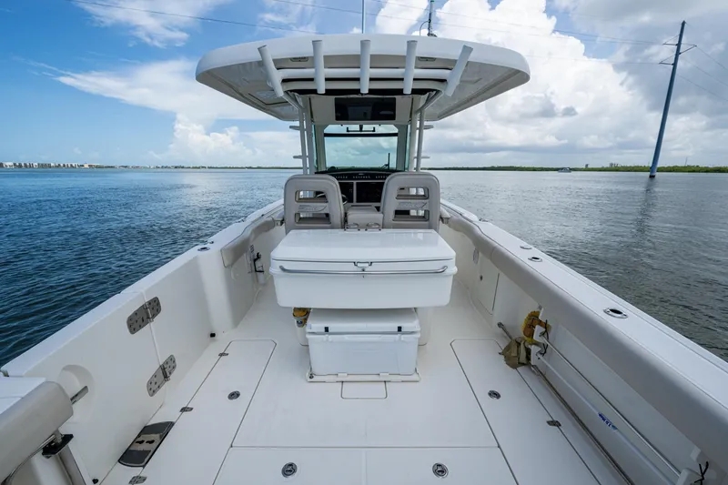 Slide: The Image of 2020 Boston Whaler 330 Outrage boat on calm water, showcasing spacious deck and seating. - 25