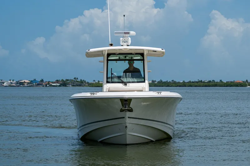 Slide: The Image of 2020 Boston Whaler 330 Outrage boat on calm water under blue sky. - 4