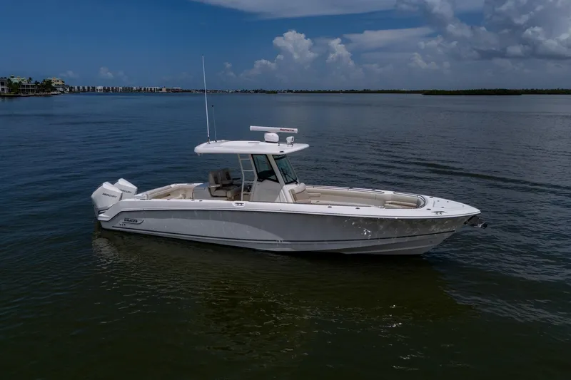 Slide: The Image of 2020 Boston Whaler 330 Outrage boat on calm water under a cloudy sky. - 5