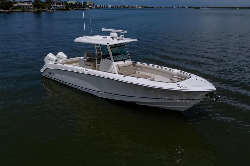 Slide: The Image of 2020 Boston Whaler 330 Outrage boat on calm water, showcasing sleek design and luxury features. - 7