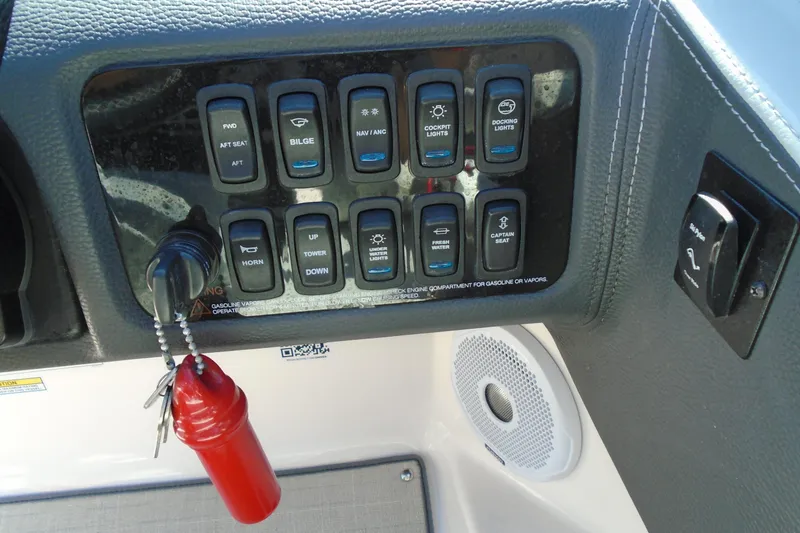 Slide: The Image of Control panel of a 2020 Regal LX4 boat with various switches and a red safety key. - 18