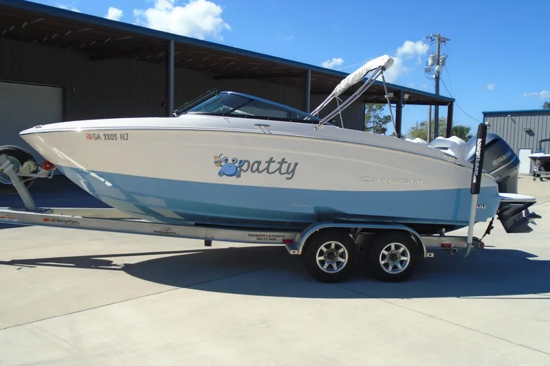 Slide: The Image of 2020 Regal LX4 boat on trailer, parked outdoors under clear blue sky. - 6