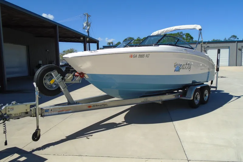 Slide: The Image of 2020 Regal LX4 boat on trailer in sunny outdoor setting. - 7