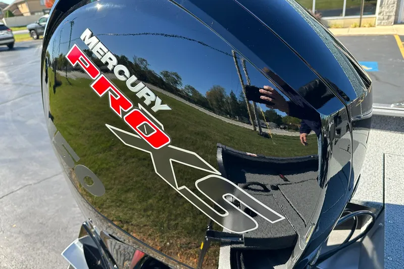 Slide: The Image of Mercury Pro XS engine on 2026 Lund 1875 Impact XS Sport boat, reflecting surroundings. - 27