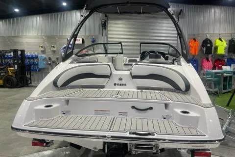 Slide: The Image of 2025 Yamaha Boats AR195 in showroom, rear view with seating and deck. - 2