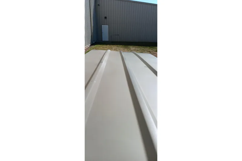 Slide: The Image of 2026 Tracker Topper 1236 boat exterior near a building, showcasing sleek design. - 15