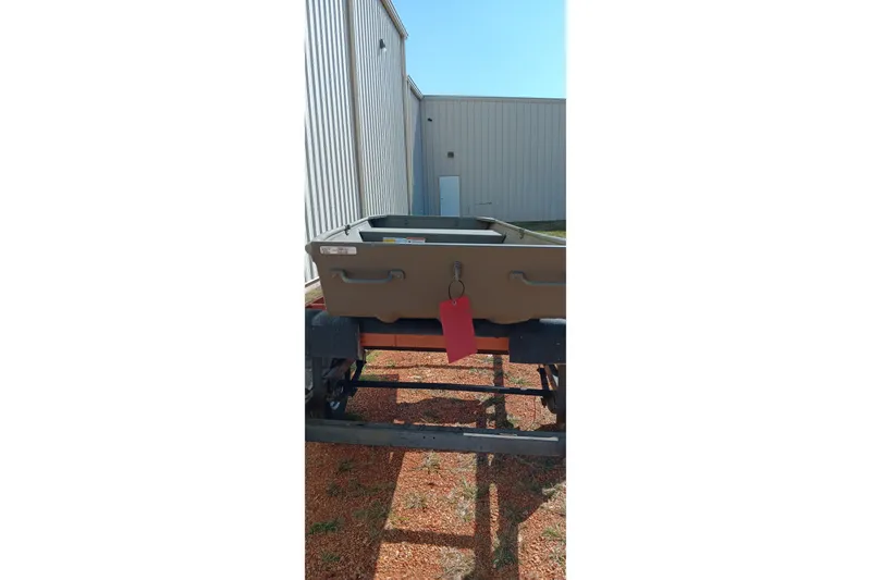 Slide: The Image of 2026 Tracker Topper 1236 boat on trailer, parked outside metal building. - 7