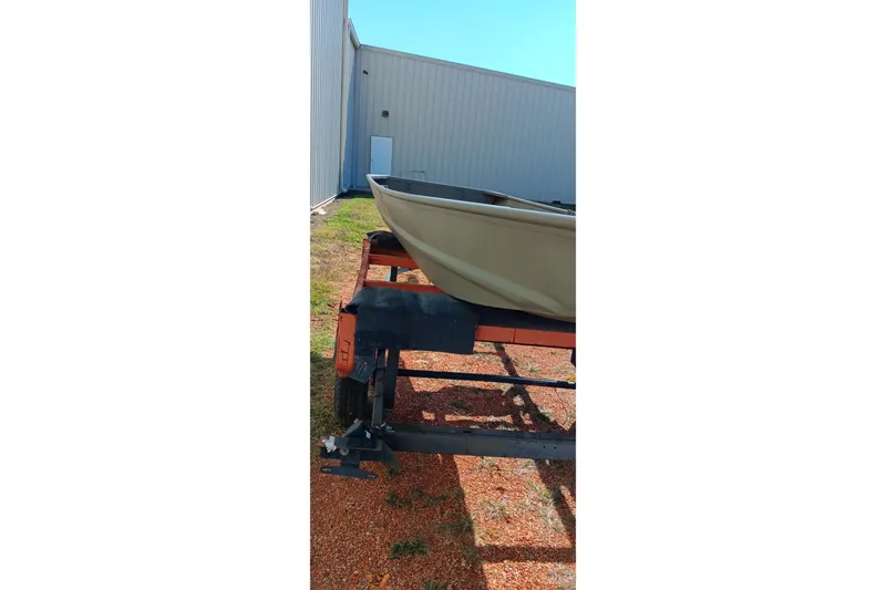 Slide: The Image of 2026 Tracker Topper 1236 boat on trailer near industrial building. - 8