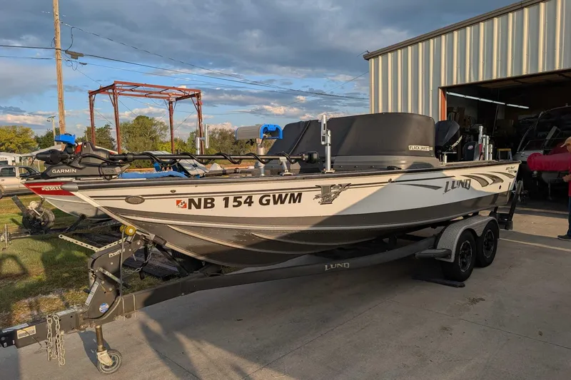 Slide: The Image of 2019 Lund 2075 Pro-V boat on trailer, parked outside a metal building. - 1