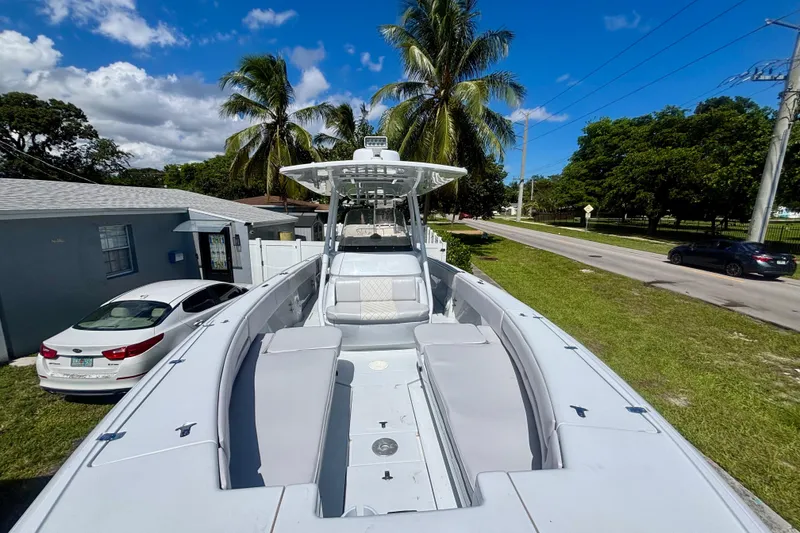 Slide: The Image of 2008 Intrepid 327 Center Console boat parked near palm trees and a residential street. - 14