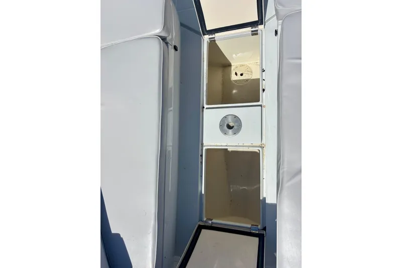 Slide: The Image of 2008 Intrepid 327 Center Console storage compartments, open and empty, showcasing interior space. - 18