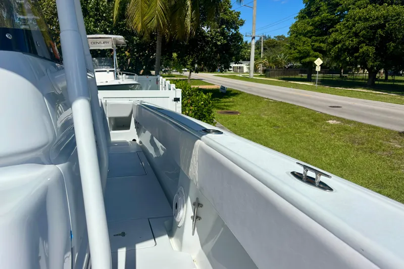 Slide: The Image of 2008 Intrepid 327 Center Console boat parked near a road with lush greenery. - 21