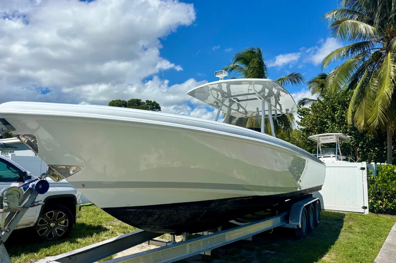 Slide: The Image of 2008 Intrepid 327 Center Console boat on trailer, surrounded by palm trees and blue sky. - 4