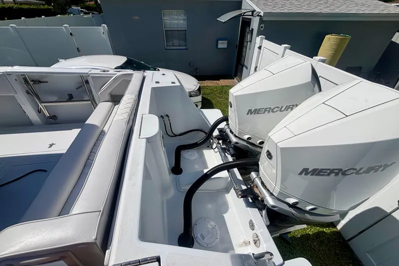 Slide: The Image of 2008 Intrepid 327 Center Console with dual Mercury outboard engines, docked near a house. - 42