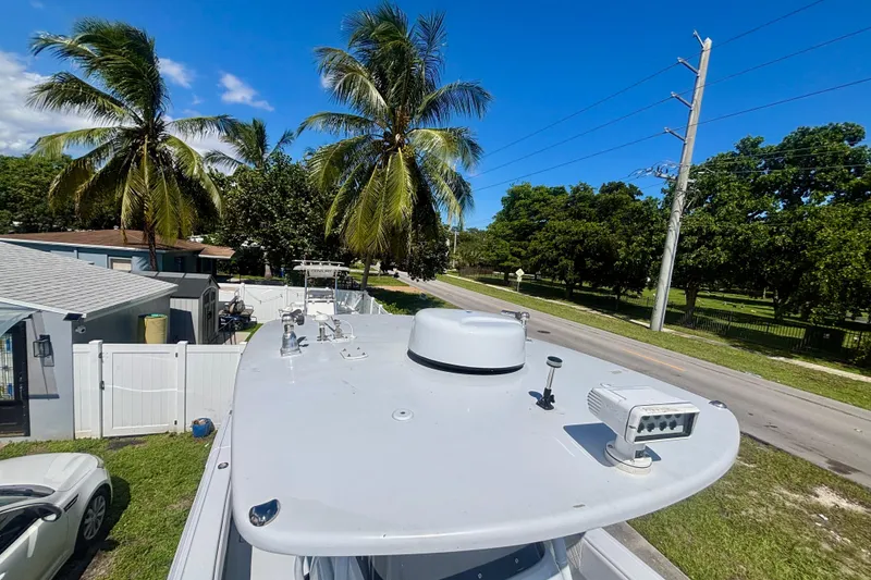 Slide: The Image of 2008 Intrepid 327 Center Console boat parked near palm trees and residential area. - 43