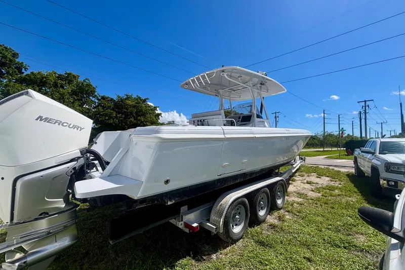 Slide: The Image of 2008 Intrepid 327 Center Console boat on trailer with Mercury engines, under clear blue sky. - 6