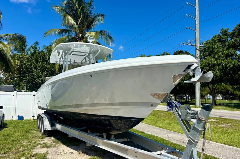 Slide: The Image of 2008 Intrepid 327 Center Console boat on trailer, surrounded by palm trees. - 7