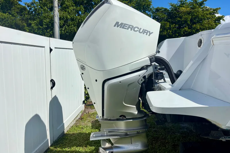 Slide: The Image of 2008 Intrepid 327 Center Console with Mercury outboard engine, parked near white fence. - 8