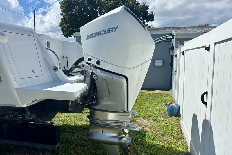 Slide: The Image of 2008 Intrepid 327 Center Console with Mercury outboard engine, parked near white fence. - 9