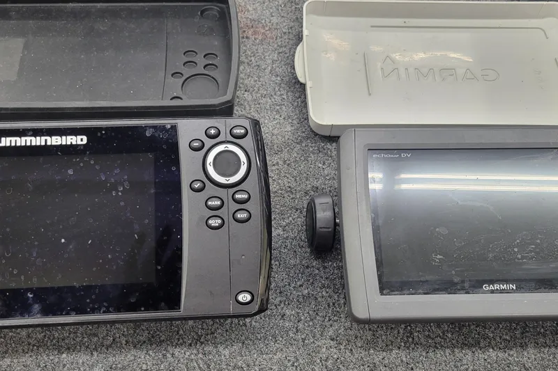 Slide: The Image of Two fish finders, Humminbird and Garmin, on a gray surface, 2016 Tracker model. - 23