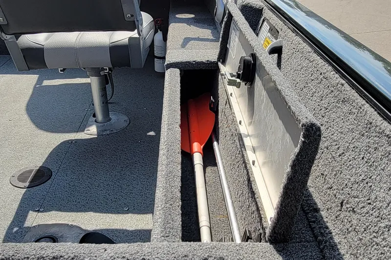 Slide: The Image of 2016 Tracker boat interior with storage compartment and paddle. - 25