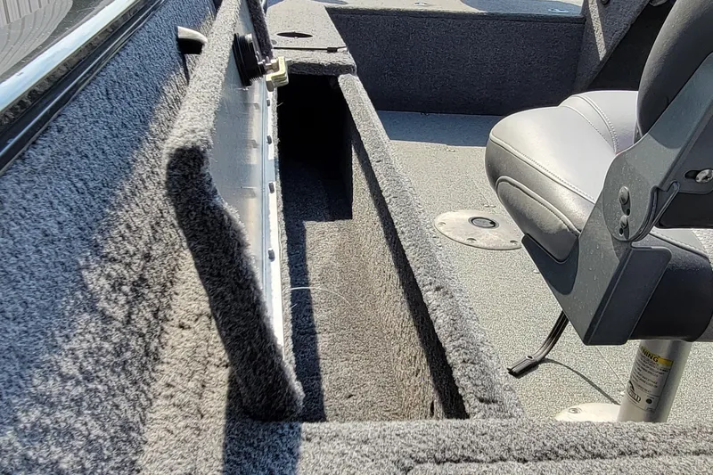 Slide: The Image of Interior of a 2016 Tracker boat showing storage compartment and seating. - 27