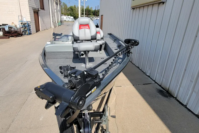 Slide: The Image of 2016 Tracker boat with Minn Kota motor, parked outdoors near a building. - 30