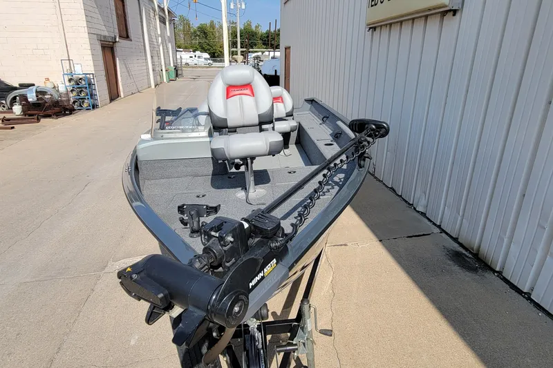 Slide: The Image of 2016 Tracker boat with Minn Kota trolling motor, parked outside a building. - 31