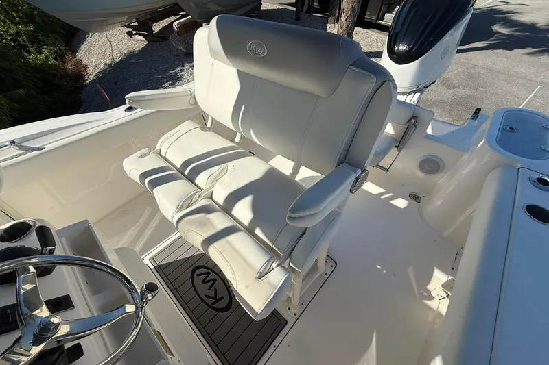 Slide: The Image of 2024 Key West 244 Center Console boat interior with white seating and steering wheel. - 7