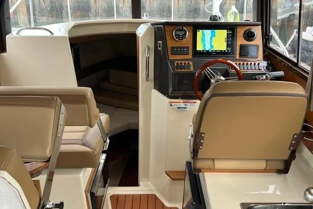 Slide: The Image of 2025 Ranger Tugs R-25 Luxury Edition interior with navigation system and plush seating. - 10