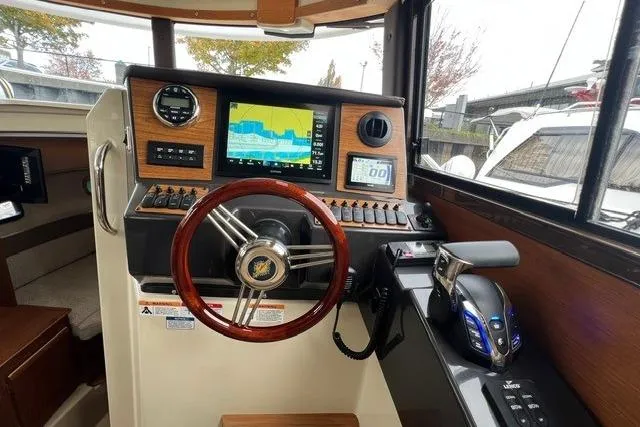Slide: The Image of Helm of 2025 Ranger Tugs R-25 Luxury Edition with advanced navigation system and wooden steering wheel. - 13