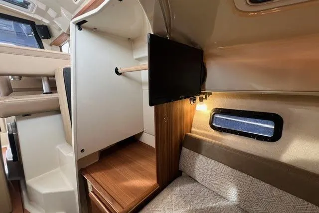 Slide: The Image of 2025 Ranger Tugs R-25 Luxury Edition interior with TV, closet, and cozy seating. - 19