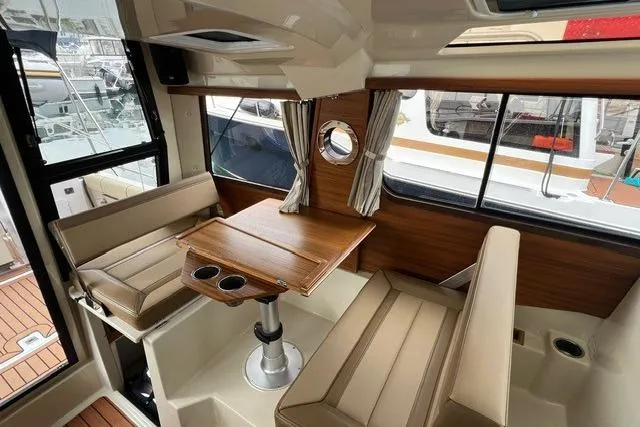 Slide: The Image of 2025 Ranger Tugs R-25 Luxury Edition interior with elegant seating and wooden table. - 22