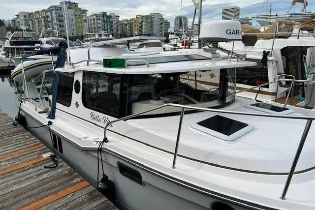 Slide: The Image of 2025 Ranger Tugs R-25 Luxury Edition docked at marina with cityscape background. - 4
